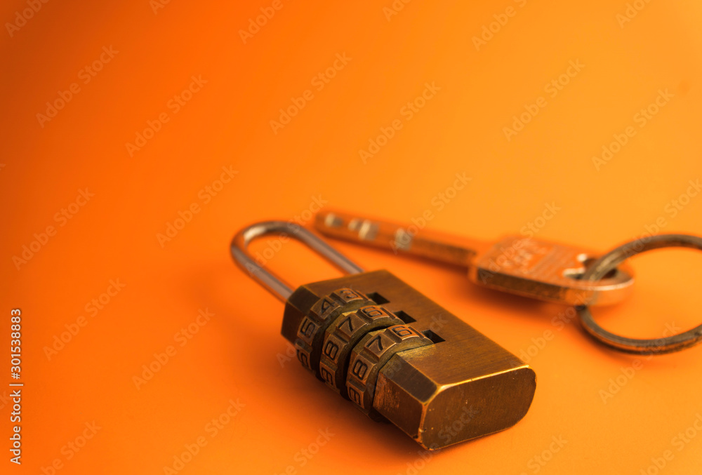 Combination padlock and key isolated on orange background. Business to success concept. Combination padlock and key isolated on orange background. Business to success concept.