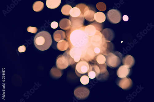 Blurred background of glowing sparks in the dark