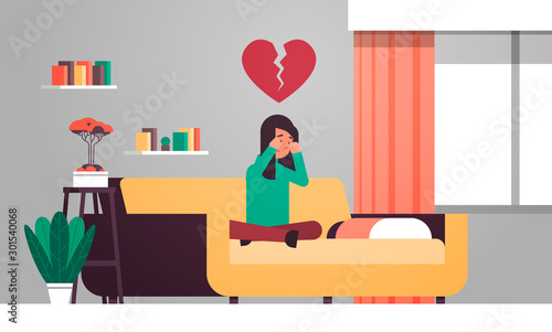 heartbroken woman in depression sitting on couch and crying life crisis break up divorce betrayal concept sad girl with broken heart modern living room interior flat horizontal vector illustration