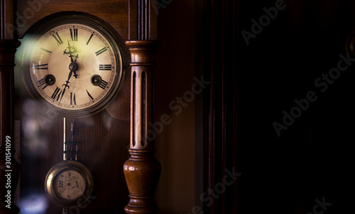 An old style wall clock from the 19th century. The clock is very old but in good condition and shows the correct time.