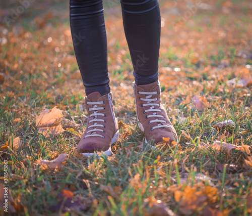 Woman legs boots in autumn nature