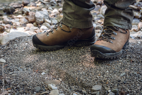 Brown trekking boots close up. Professional hiking equipment. A man stands in tourist shoes.