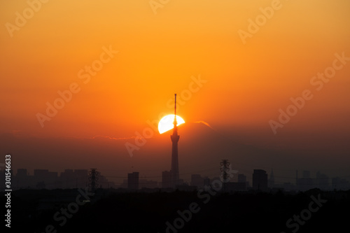 Sun setting behind Tokyo Skytree and Mount Fuji in autumn, from Chiba Prefecture, Japan