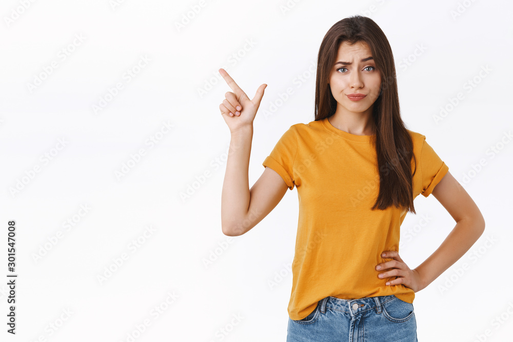 Skeptical arrogant and displeased young woman find new product suspicious and unworthy her attention, smirk with disdain, frowning judgemental pointing upper left corner Skeptical arrogant and displeased young woman find new product suspicious and unworthy her attention, smirk with disdain, frowning judgemental pointing upper left corner