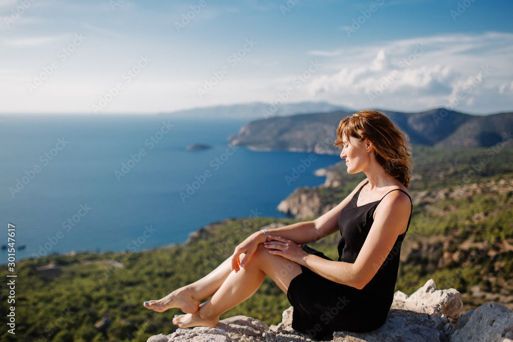 View from Monolithos, landscape at the island Rhodes, Greece. Girl admires the beauty of the landscape View from Monolithos, landscape at the island Rhodes, Greece. Girl admires the beauty of the landscape