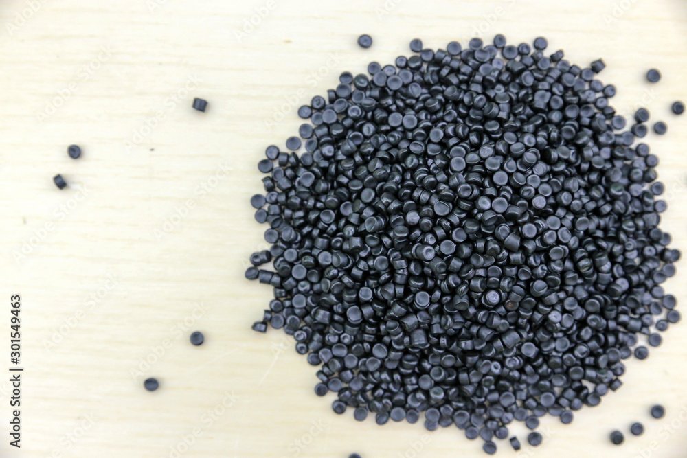 Close-up of plastic polymer granules. Polymer pellets on Wooden blackground. polymer plastic. compound polymer. plastic recycle. Close-up of plastic polymer granules. Polymer pellets on Wooden blackground. polymer plastic. compound polymer. plastic recycle.