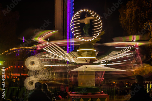 A blurry colorful carousel in motion at the amusement park, night illumination. Long exposure. photo