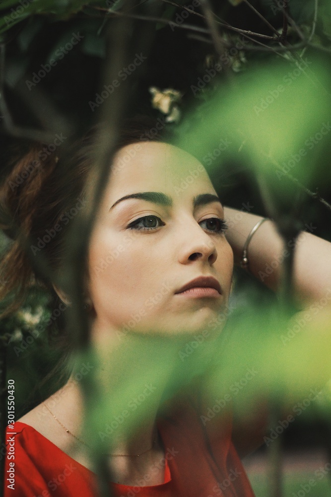 Young pretty girl's portrait on parkland background