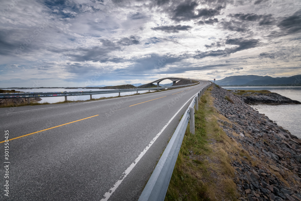 Low view of Atlantic road curved bridge with clouded sky Norway