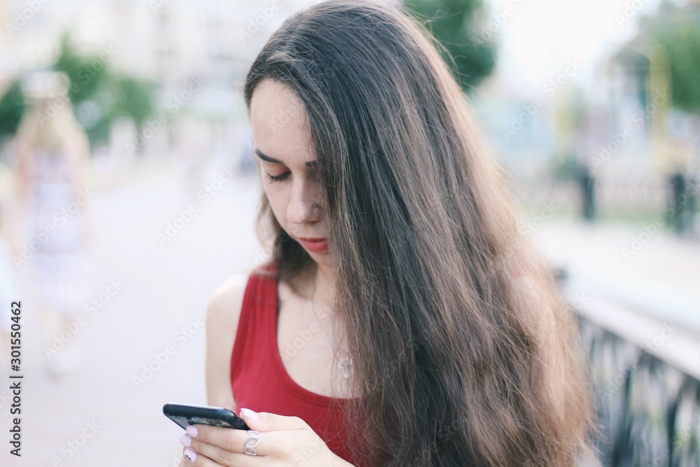 Young pretty girl's using smartphone with city on background