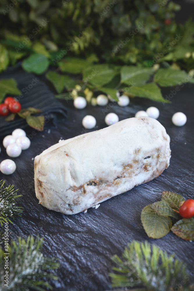 Fototapeta premium Full traditional German christmas season sweet food called 'Stollen' or 'Christstollen', a fruit bread of nuts, spices, and dried or candied fruit, coated with powdered sugar