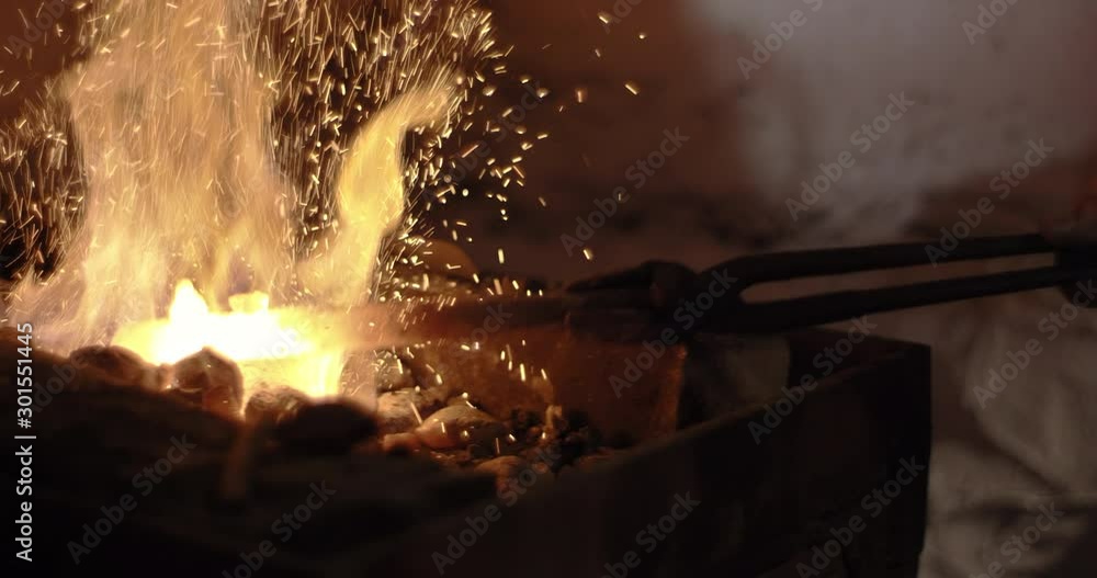 Blacksmith Poking At Red Hot Coals With Steel Rod Blacksmith Poking At Red Hot Coals With Steel Rod