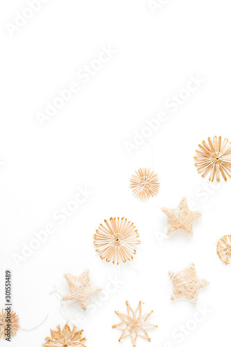 Traditional straw decorations on white background. Flat lay, top view Christmas / New Year minimal composition.
