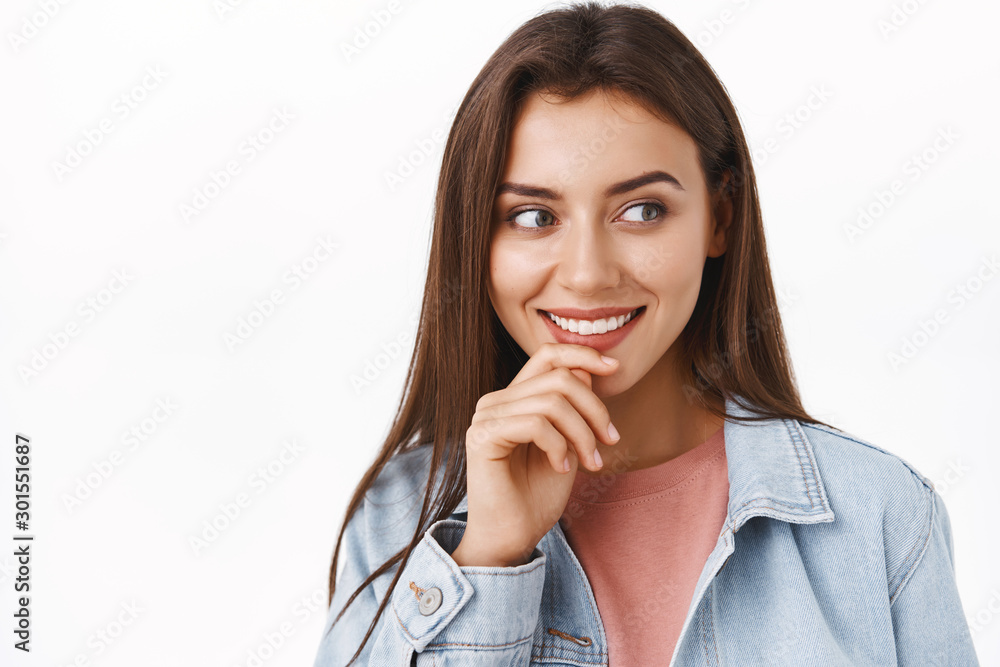 Curious and intrigued alluring modern woman in denim jacket, look at something tempting and entertaining, touch lip thoughtful, smiling, beaming from interest, stand white background Curious and intrigued alluring modern woman in denim jacket, look at something tempting and entertaining, touch lip thoughtful, smiling, beaming from interest, stand white background