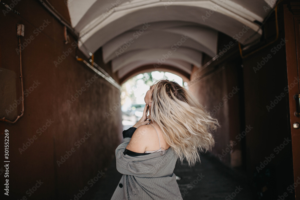 Fototapeta premium street portrait of a long-haired blonde in an arch.