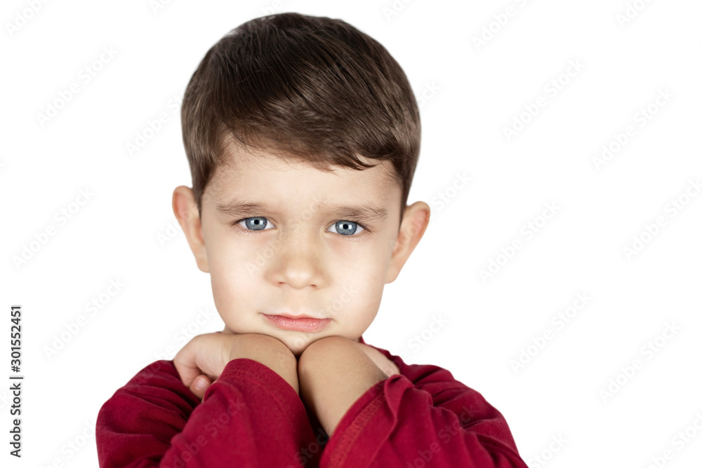 Portrait of young handsome boy with blue eyes and serious face on a white background, isolated. The boy begins to smile Portrait of young handsome boy with blue eyes and serious face on a white background, isolated. The boy begins to smile