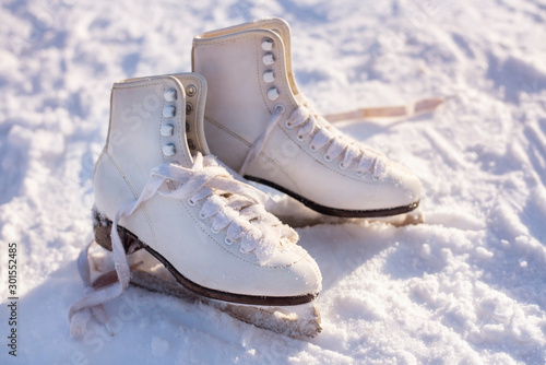 White girls ice skates lie on the snow. Winter sports concept