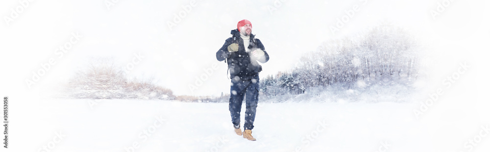 A man travels with a backpack. Winter hike in the forest. Tourist on a walk in the winter in the park. A man travels with a backpack. Winter hike in the forest. Tourist on a walk in the winter in the park.