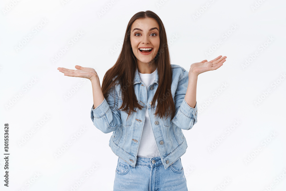 Cheerful, happy and relieved good-looking brunette female in denim jacket, jeans, spread hands sideways showing unbothered, relaxed emotion, laughing and smiling as did not expect good outcome Cheerful, happy and relieved good-looking brunette female in denim jacket, jeans, spread hands sideways showing unbothered, relaxed emotion, laughing and smiling as did not expect good outcome