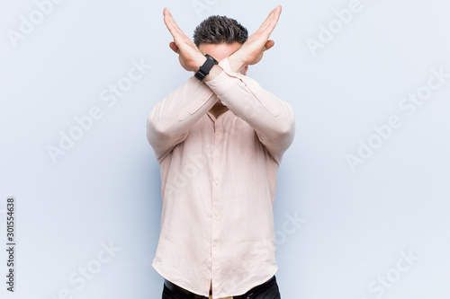 Young handsome cool man keeping two arms crossed, denial concept.