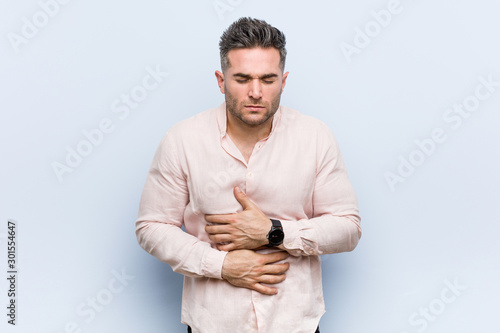 Young handsome cool man sick, suffering from stomachache, painful disease concept.