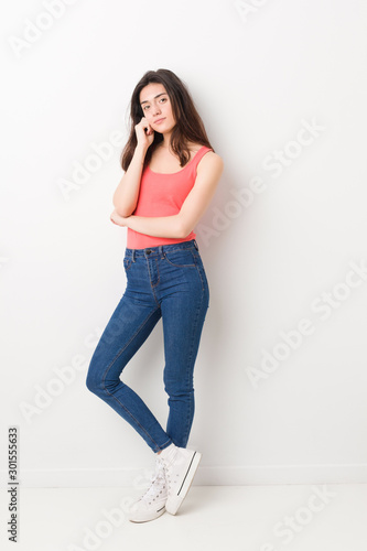Young caucasian woman standing against a white background