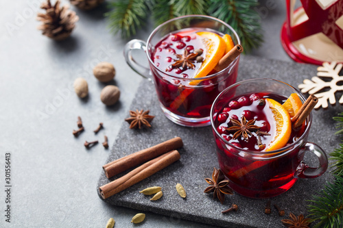 Mulled red wine with spices. Christmas decoration. Grey stone background. Copy space.