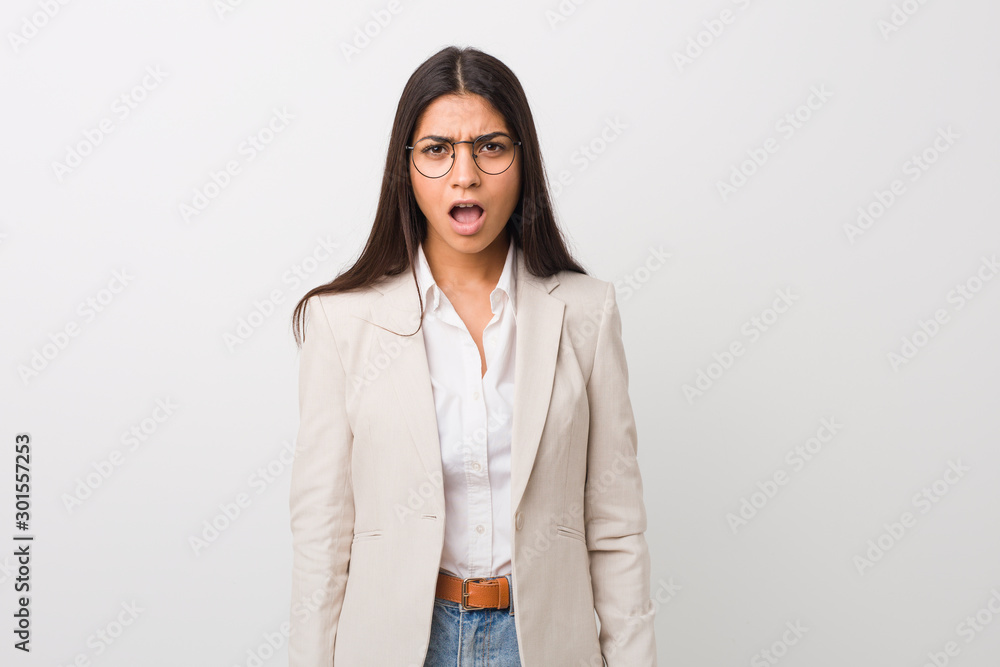Young business arab woman isolated against a white background screaming very angry and aggressive. Young business arab woman isolated against a white background screaming very angry and aggressive.