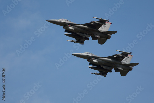 Two F16 Fast fighter jets fully loaded in formation flypast