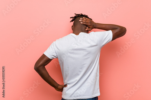 Young african black man from behind thinking about something.