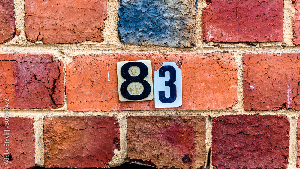 The number 83 is stuck to a brick wall as a grunge style house number. The number 83 is stuck to a brick wall as a grunge style house number.