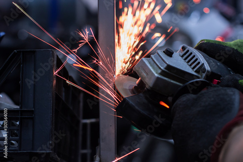 Worker cutting metal in the garage