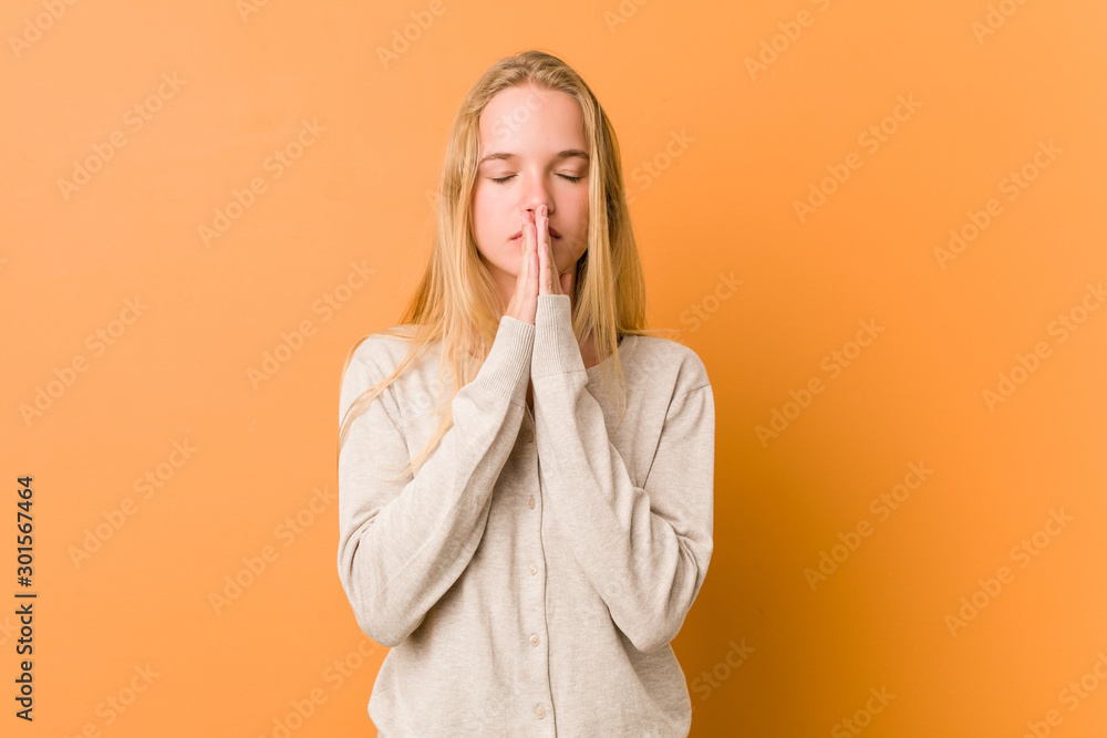Cute and natural teenager woman holding hands in pray near mouth, feels confident. Cute and natural teenager woman holding hands in pray near mouth, feels confident.