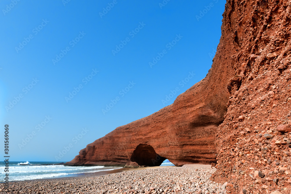 Natural sea-worn rock archways at Legzira beach, Morocco.