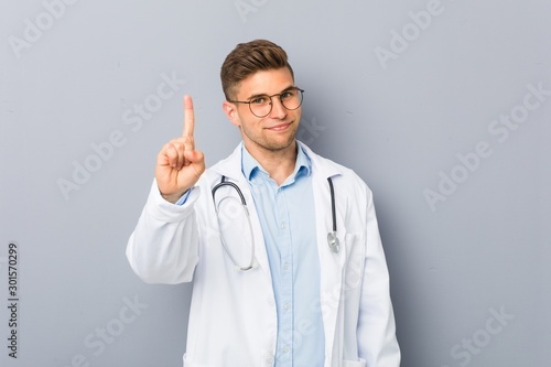 Young doctor man showing number one.