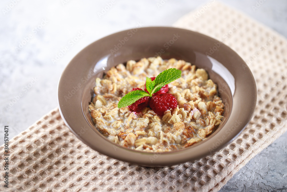 Baked granola with milk and raspberries with mint in a plate. Healthy breakfast. Tasty muesli, snack. top shot Baked granola with milk and raspberries with mint in a plate. Healthy breakfast. Tasty muesli, snack. top shot