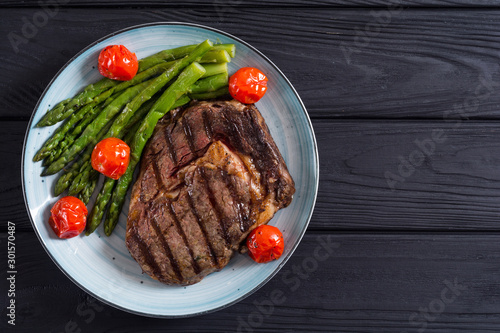 Grilled beef steak ribeye with cherry tomatoes and asparagus