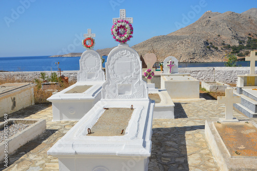 Typische stilvolle Grabgestaltung auf dem Friedhof von Emborios oder Imborios auf der griechischen Insel Chalki mit der südlich gelegenen Bucht im Hintergrund 9 km nördlich von Rhodos photo