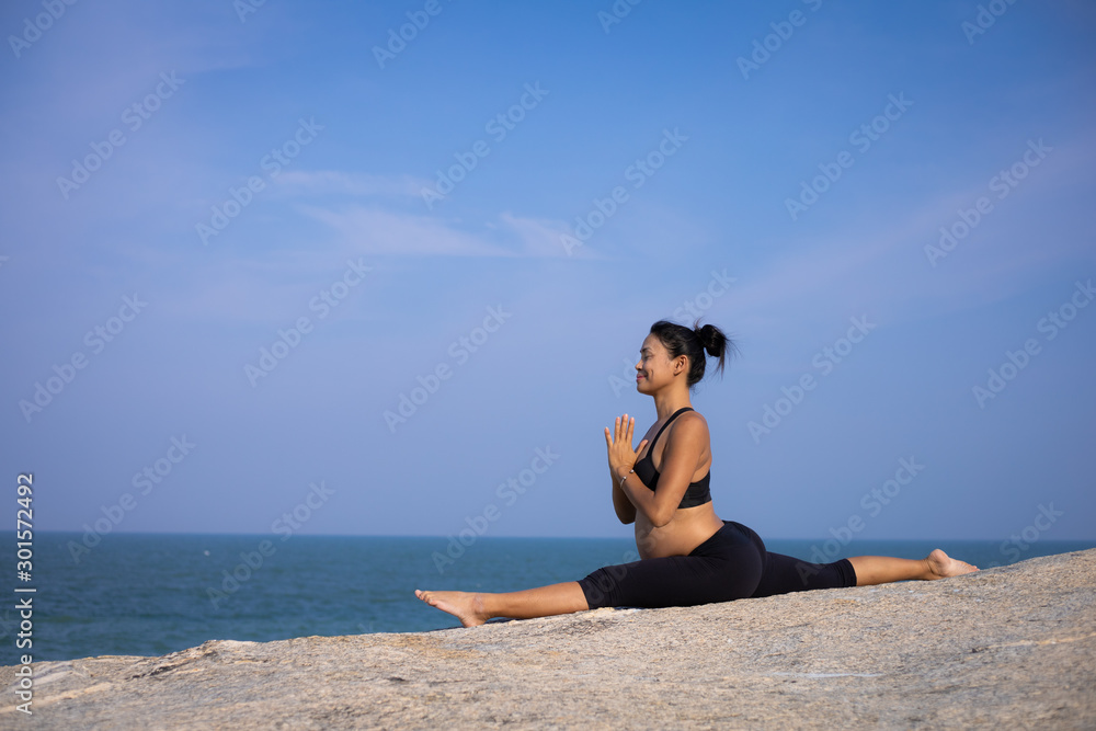 Asian pregnant woman yoga on the beach sunset summer time Asian pregnant woman yoga on the beach sunset summer time