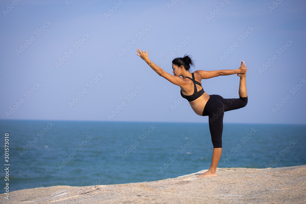 Asian pregnant woman yoga on the beach sunset summer time Asian pregnant woman yoga on the beach sunset summer time