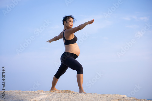 Fototapeta Naklejka Na Ścianę i Meble -   Asian pregnant woman yoga on the beach sunset summer time