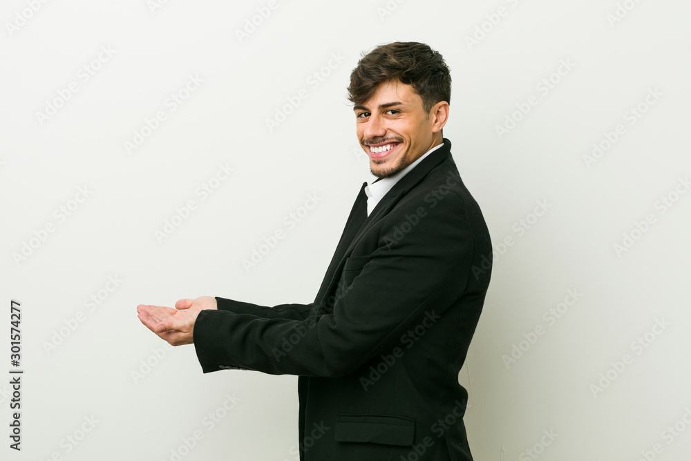 Young business hispanic man holding a copy space on a palm. Young business hispanic man holding a copy space on a palm.