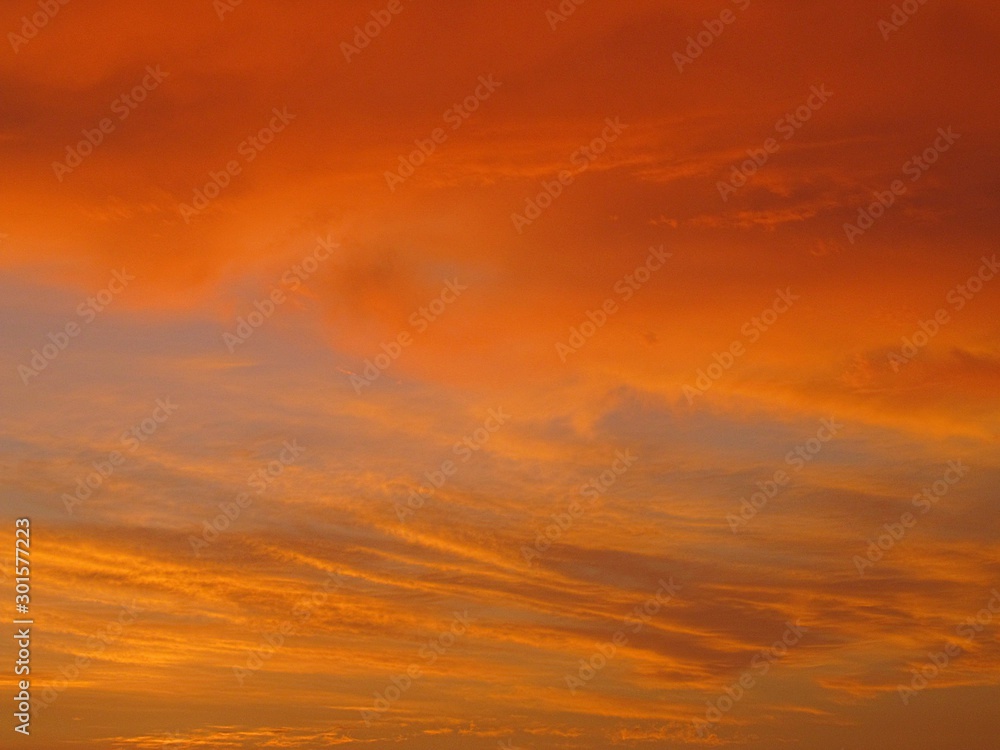 An orange evening sky with clouds