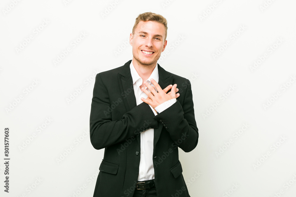 Young caucasian business man has friendly expression, pressing palm to chest. Love concept. Young caucasian business man has friendly expression, pressing palm to chest. Love concept.