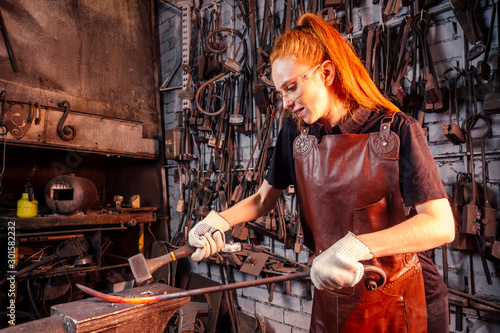 Fotografia redhead ginger woman blacksmith portrait in workshop