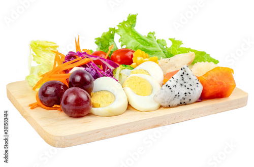 Fruit and vegetable salad with meat and boiled eggs on a white background.