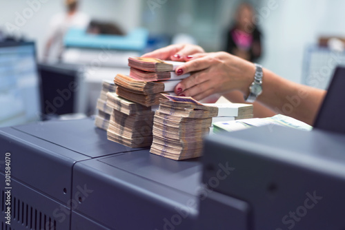 Bank employees sorting and counting money inside bank vault. Large amounts of money in the bank.