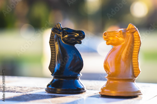 Knight chess piece faces off other figures in a game of chess. Challenge concept.