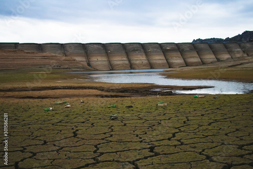 Dam and a small lake in an arid dried out ground.