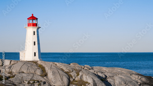 Peggys Cove lighthouse on a sunny day with blue sky.